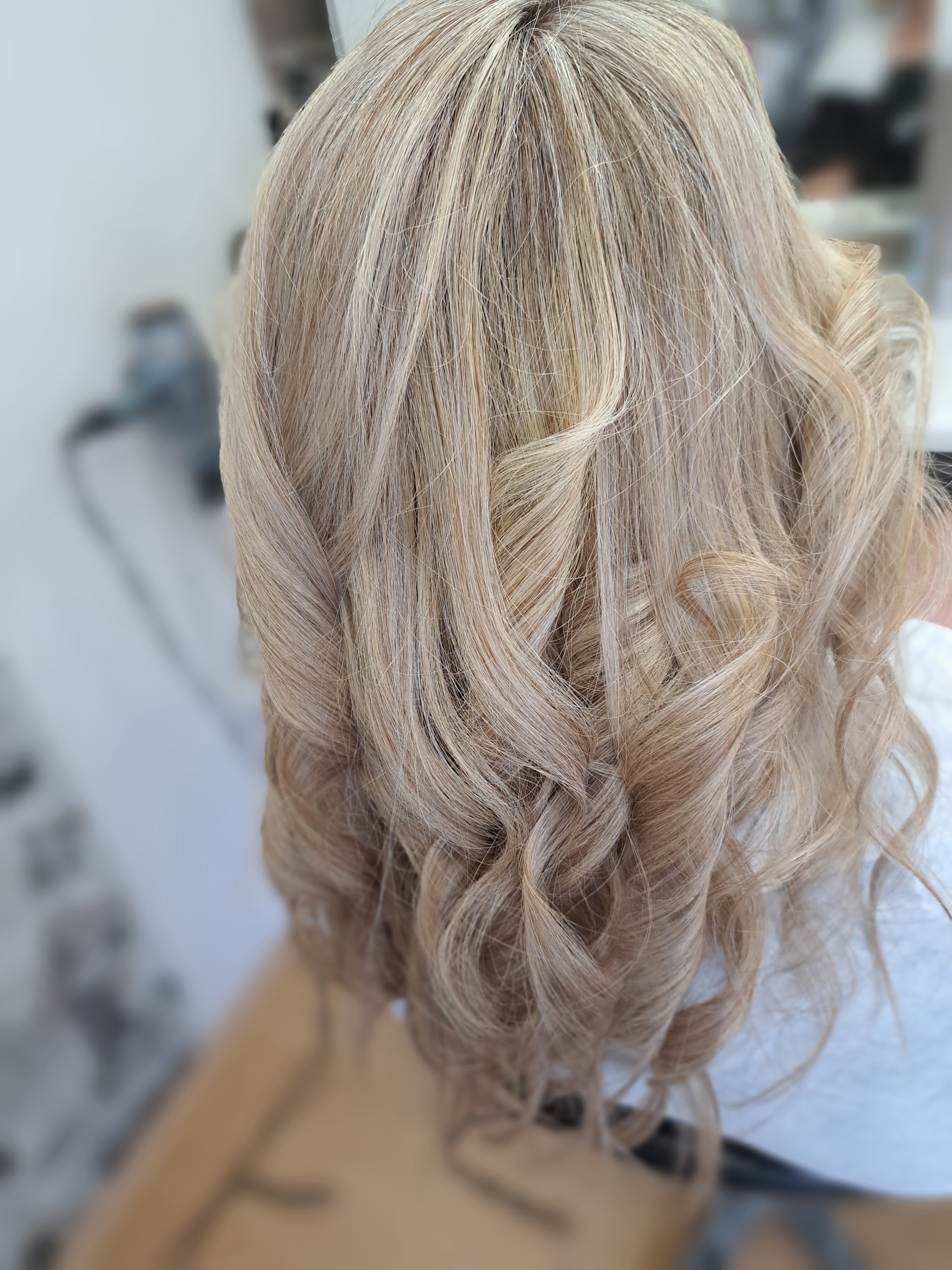 Lang blond haar met losse krullen, van achteren gezien