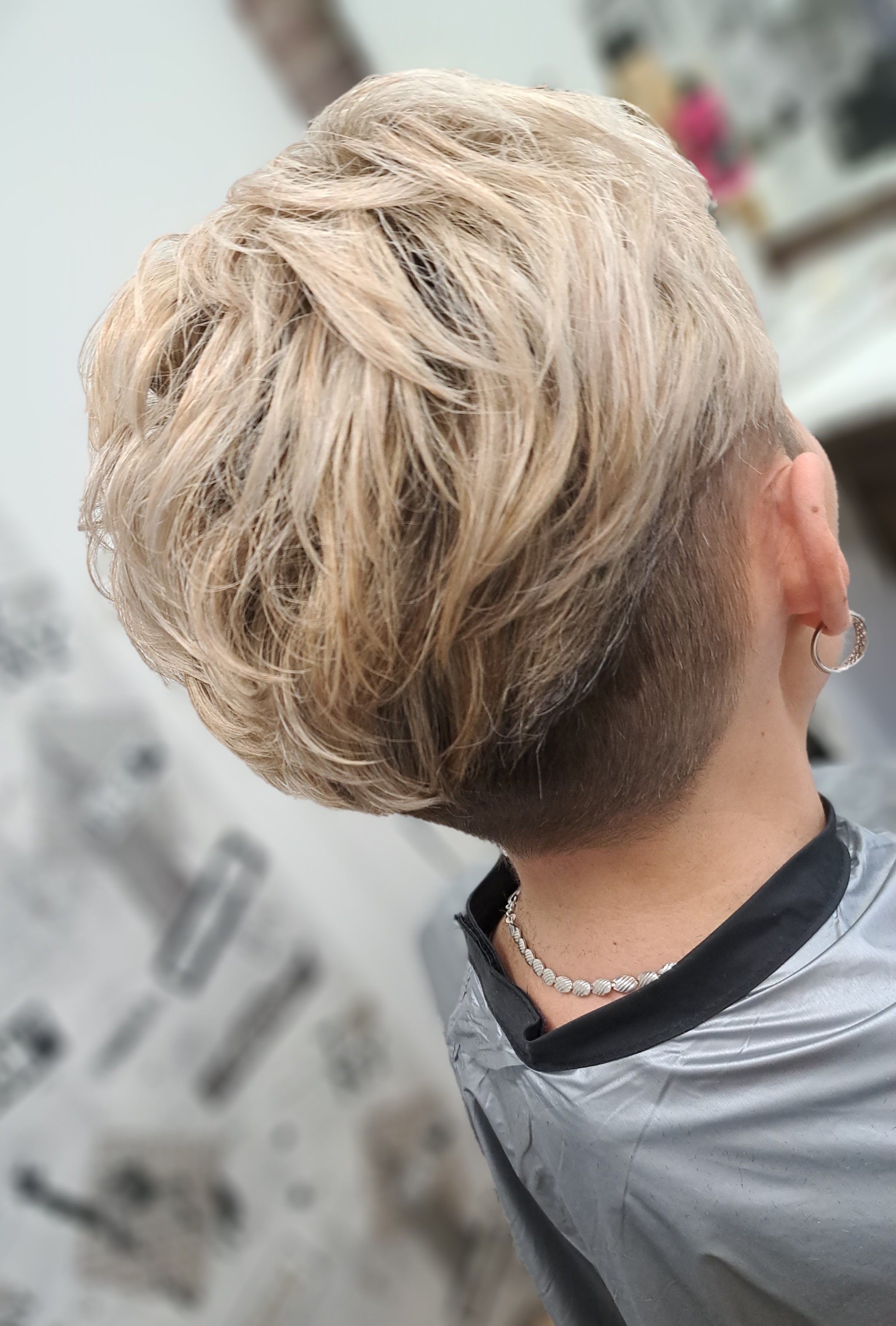 Korte blonde coupe met opgeschoren zijkant, van opzij
